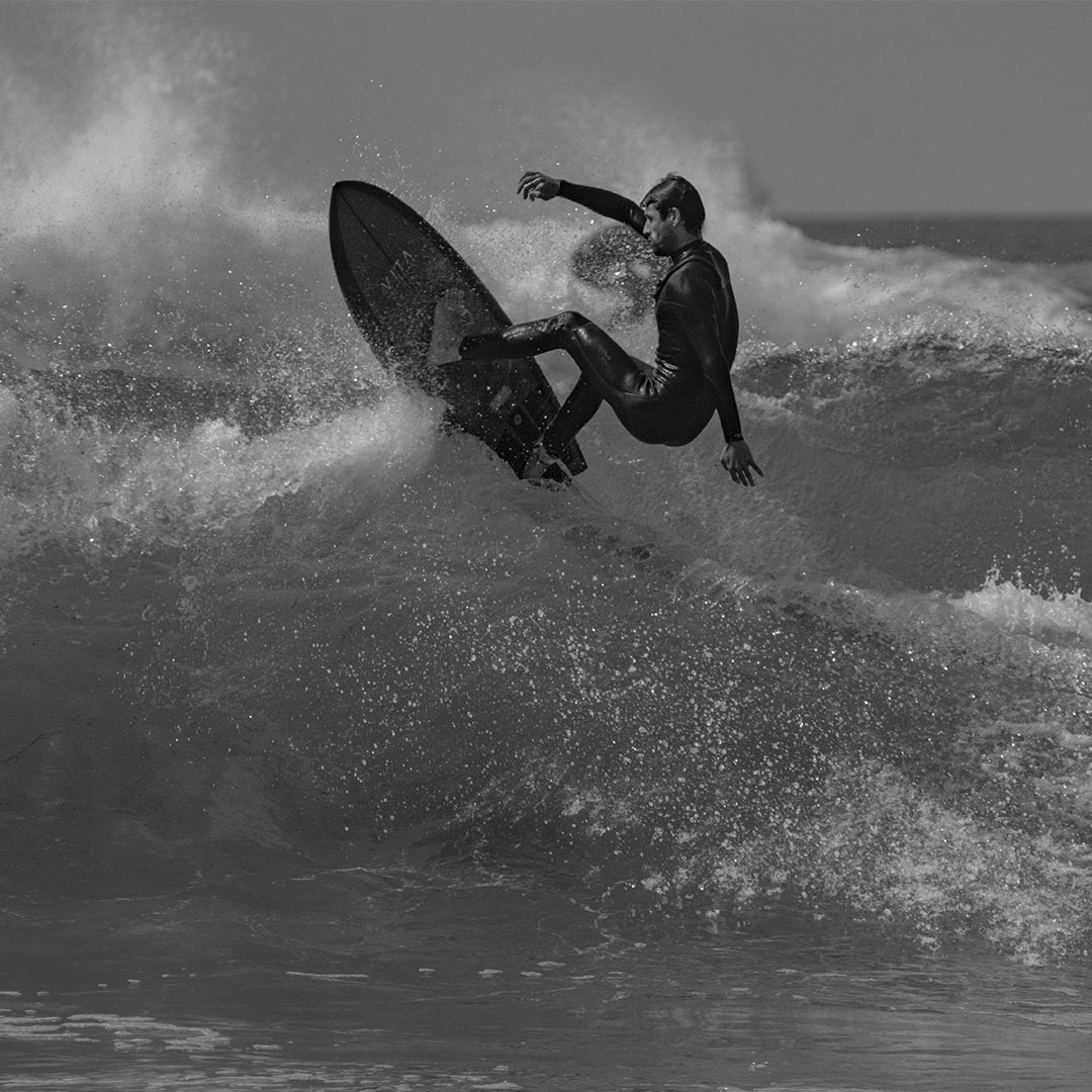 chico cogiendo una ola con su tabla de surf